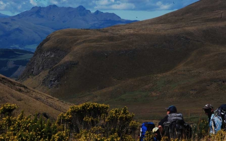 Students stand before a vast mountainous landscape
